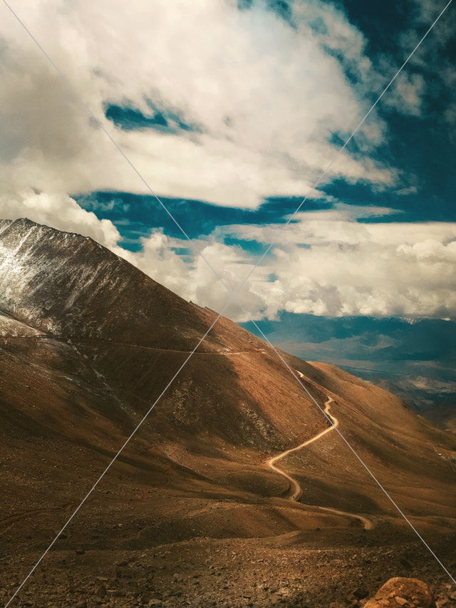 brown mountain under white clouds